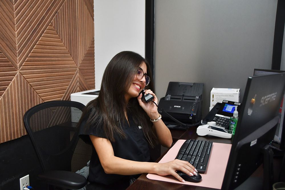 A Davie ObGyn patient care advocate helping a caller at the front desk